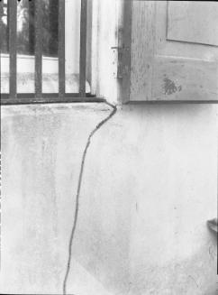 Untitled (barred window and stone wall)