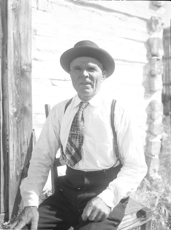 Untitled (man seated wearing hat and suspenders)