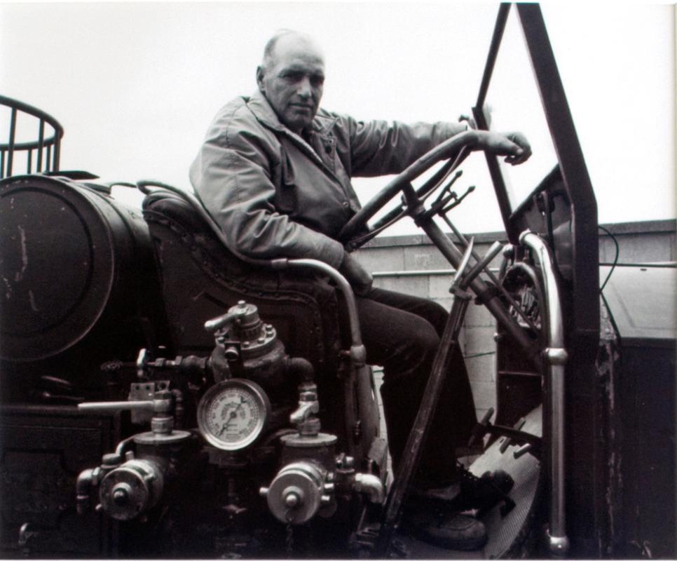 Regina Firefighters Museum. Wes Turner on a 1928 L. A. France fire engine awaiting restoration, 1981