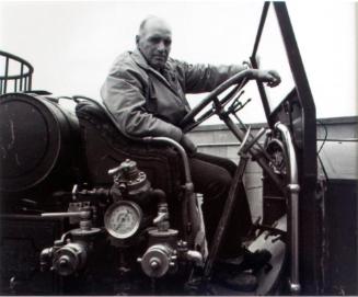 Regina Firefighters Museum. Wes Turner on a 1928 L. A. France fire engine awaiting restoration, 1981