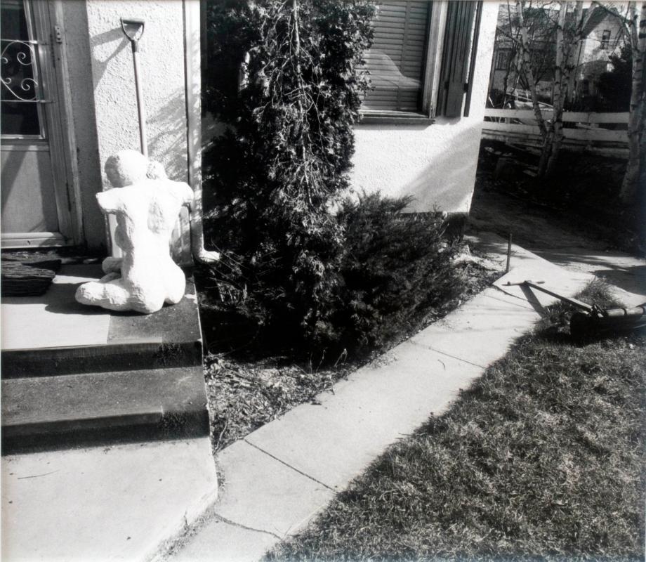 Statue and Shovel by a House