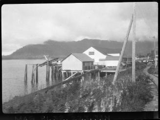 Untitled (buildings on stilts by lake and railway track)