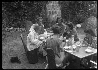 Untitled (group at picnic table outside cabin)