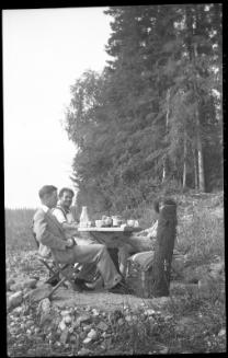 Untitled (people at table in woods)