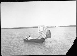 Untitled (woman in boat with sun umbrella)