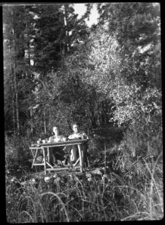 Untitled (couple at picnic table in woods)