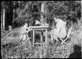 Untitled (couple sitting at table in woods)